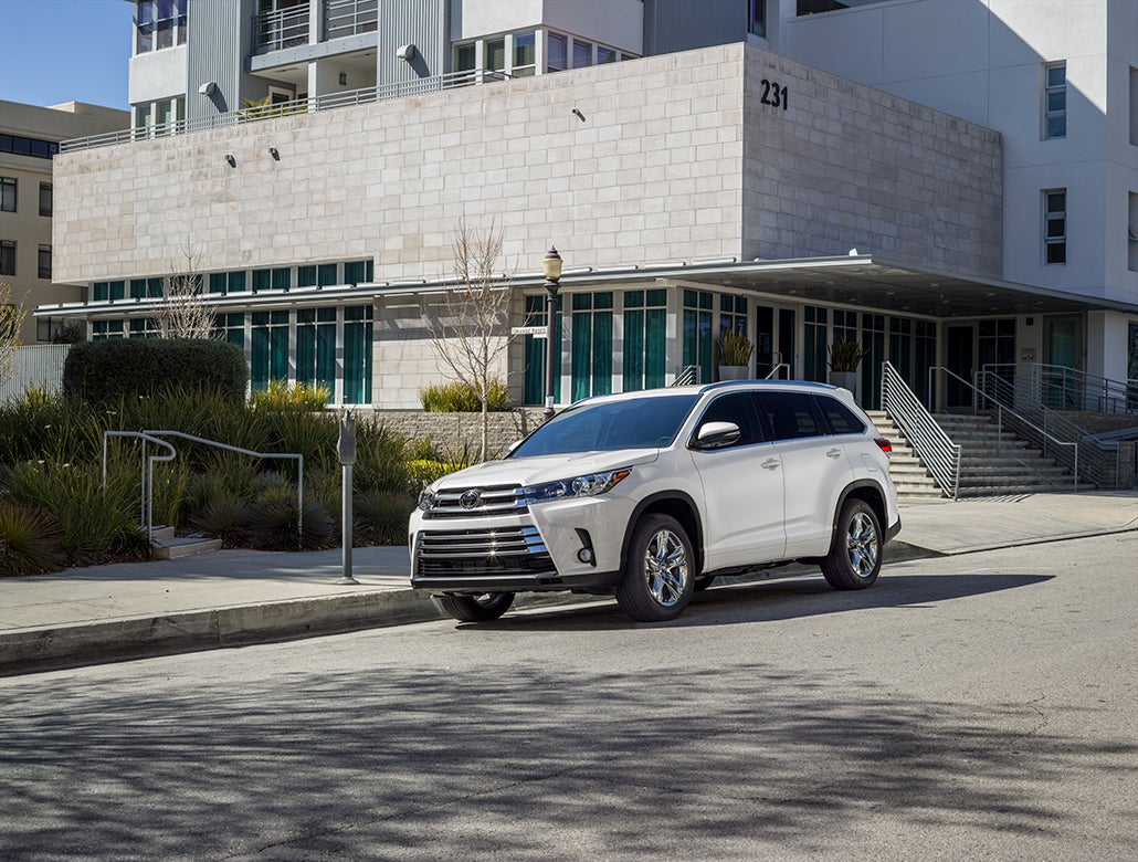 Comparison of the 2019 Toyota Highlander vs. the 2019 Honda Pilot at Fiore Toyota of Hollidaysburg | White Toyota highlander parked outside a building