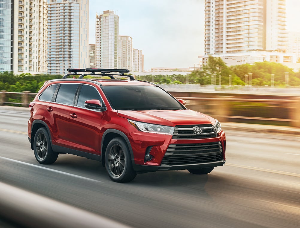 Comparison of the 2019 Toyota Highlander vs. the 2019 Honda Pilot at Fiore Toyota of Hollidaysburg | Red Toyota highlander running on road