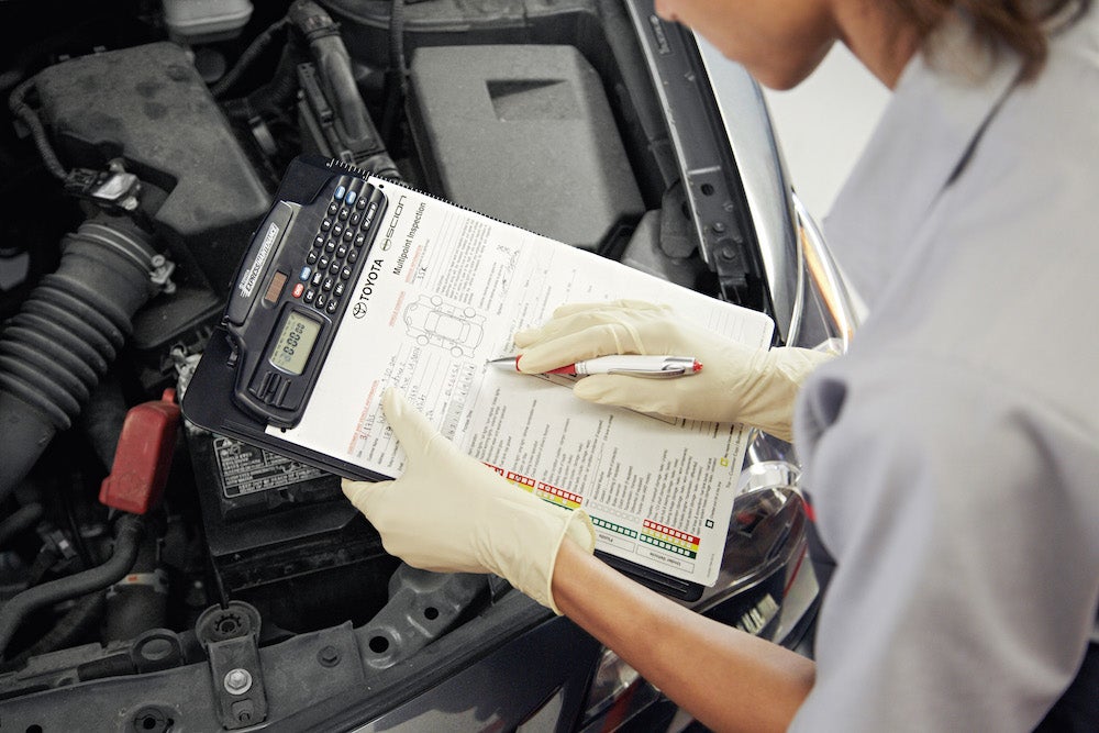 ToyotaCare in Hollidaysburg at Fiore Toyota | Toyota technician holding vehicle checkboard