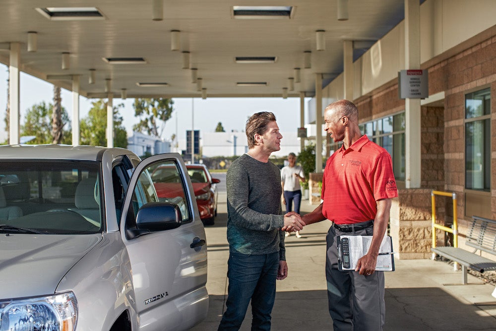 F&I Products page at Fiore Toyota in Hollidaysburg | Man shaking hand with toyota Technician
