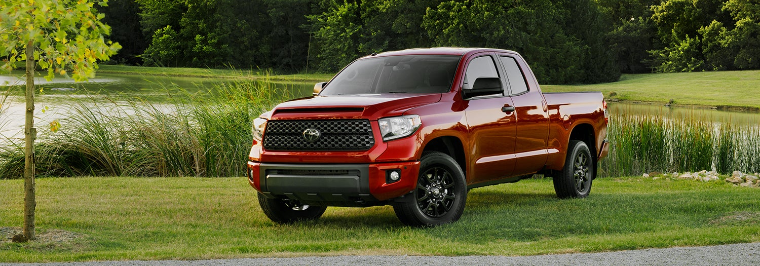 Comparison of the Toyota Tacoma vs. Tundra trucks at Fiore Toyota of Hollidaysburg | Red Toyota Tundra parked on road