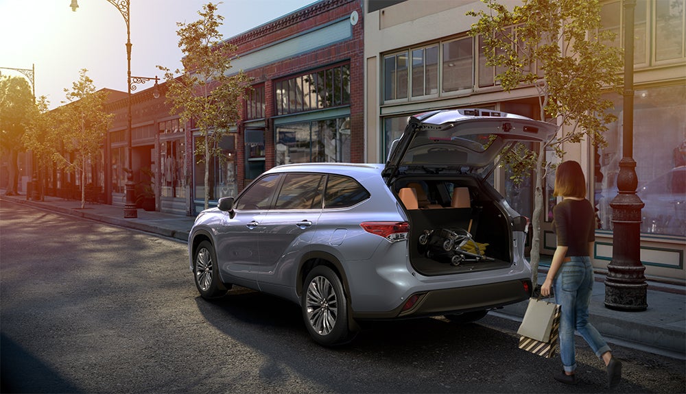 The 2020 Toyota Highlander coming soon to Fiore Toyota of Hollidaysburg | woman opening the trunk of the 2020 highlander